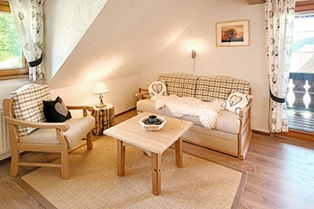 Schlafzimmer mit Doppelbett, Sitzecke und Zugang zum Balkon