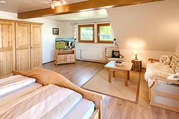 Schlafzimmer mit Doppelbett, Sitzecke und Zugang zum Balkon